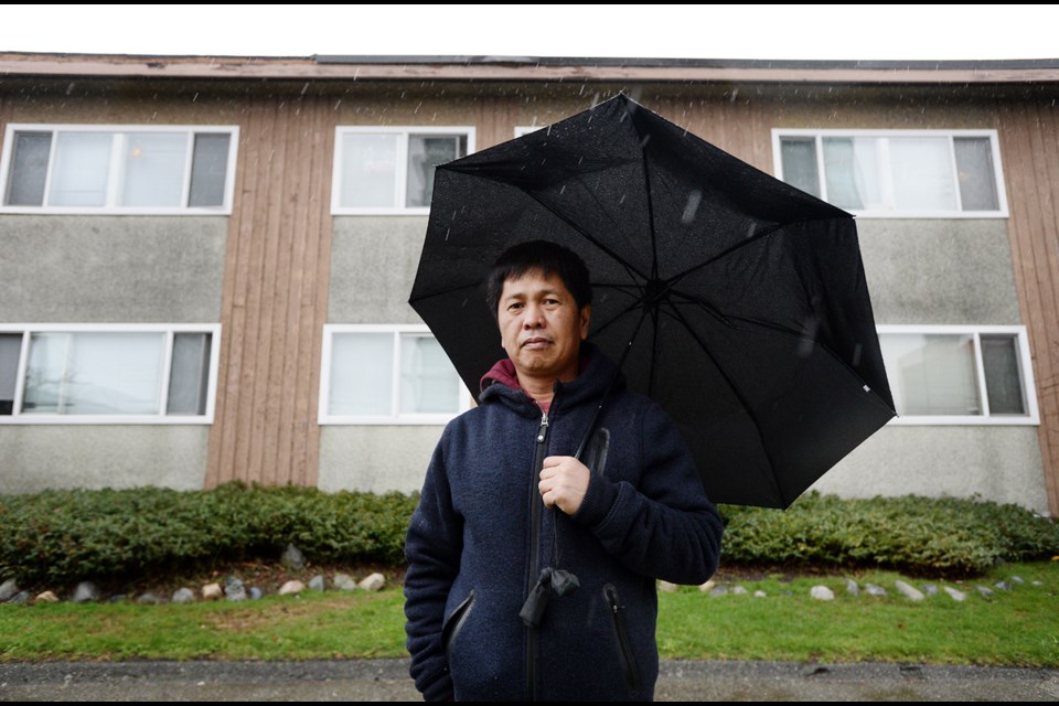 Nathan Cunan stands outside his Dow Avenue apartment building on a rainy Sunday afternoon.