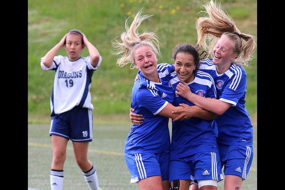 MARIO BARTEL/THE TRI-CITY NEWS
Centennial Centaurs forward Sophia Ferreira, centre, is hugged by teammates Meghan Harder and Raegan Mackenzie, after she scored the winning goal in their 1-0 win over the Fleetwood Park Dragons in Friday's BC High School AAA senior girls soccer championship at the University of British Columbia's Thunderbird Stadium. Shooting sports is part luck, part intuition and part absorbed knowledge. Time was running out in the senior girls high school soccer championship that was scoreless late in the match so I moved from my usual shooting position along the end touch line to a spot on the sideline between the benches to better my chances of capturing any sort of reaction should a goal be scored. Then, it was.
