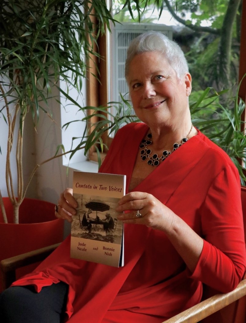Jude Neale holds her new co-authored book Cantata in Two Voices.