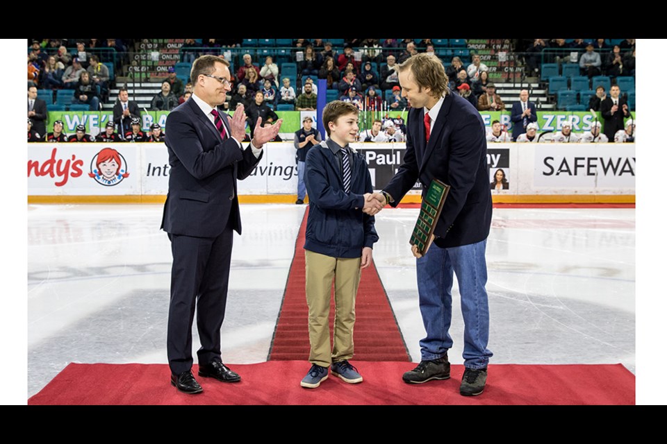 Kamloops International Bantam Ice Hockey Tournament chairman Jan Antons shakes hands with Rylan Davis before handing him the Adam Herold Award at Sandman Centre on Saturday. The award recognizes a KIBIHT player who shows courage and perseverance. On the left is Mike Dumelie, who coached Herold when he played for Balgonie. Herold was killed last year in the tragic Humboldt Broncos bus crash.
