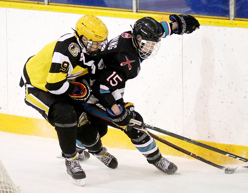 MARIO BARTEL/THE TRI-CITY NEWS
Coquitlam A1 Chiefs John Favaro battles Central Rockets forward Spencer Horning for control of the puck in the second period of their game at the Coquitlam Minor Hockey Association's annual Midget A tournament held at the Poirier Sports and Leisure Complex and Planet Ice last weekend. The tournament attracted 19 teams from across the Lower Mainland, Vancouver Island and the United States. South Okanagon won Tier 1, Aldergrove A1 won Tier 2, and New West A1 won Tier 3. But CMHA teams had better success at its Midget C tournament which also wrapped up on Sunday as the home team swept the medals amongst 15 teams from across the Lower Mainland: Coquitlam C2 won gold; Coquitlam C5 won silver; and bronze when to Coquitlam C1.