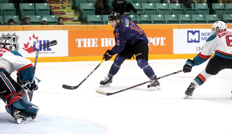 Cougars winger Josh Maser gets set to release a backhander on Kelowna Rockets goalie Roman Basran while Rockets defenceman Kaeden Korczak defends during Saturday's game at CN Centre. The Cougars skated to a 4-0 victory.