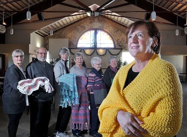 Laura Hughes, right, leads a group of volunteers at St. Clare of Assisi Catholic church in Coquitlam who knit and distribute prayer shawls to cancer patients. The volunteers include, L-R: Jennifer Durkin; Father Craig Scott; Margaret Popkey; Anita Carlin; Ann Cooke; and Eileen Richter.