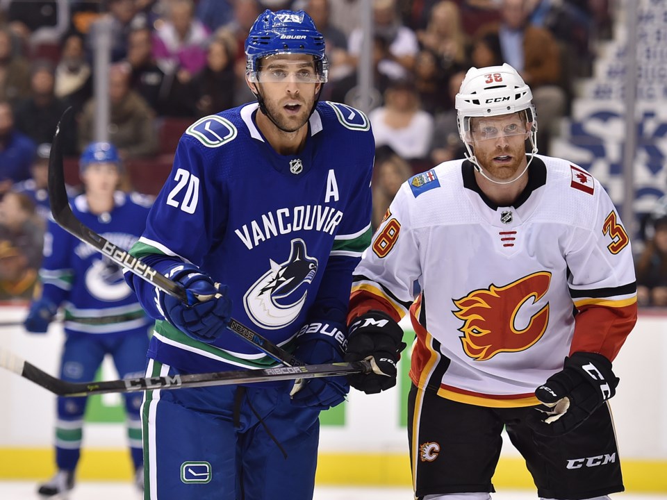 Brandon Sutter battles with a member of the Calgary Flames during the Vancouver Canucks preseason