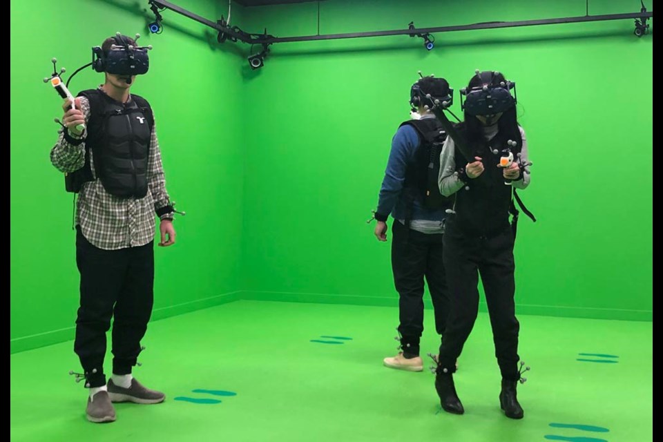 Richmond News reporter Daisy Xiong (right) experience one of Canada's first virtual reality shooter gaming centre in Richmond on Monday.