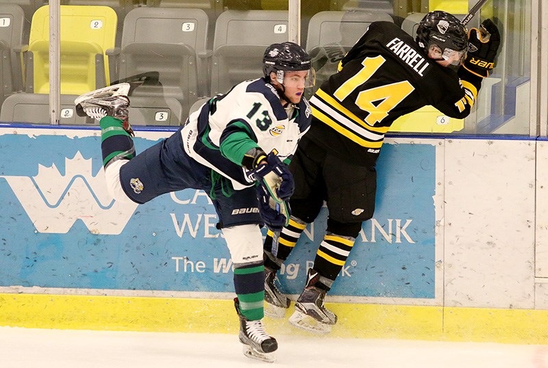 Coquitlam Express forward Dallas Farrell crashes into the boards after missing his check on Surrey Eagles defenceman Jesse Conroy in the first period of their BC Hockey League game, Wednesday afternoon at the Poirier Sports and Leisure Complex.
