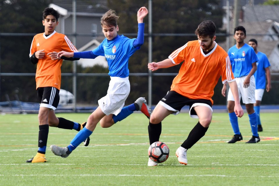 New Westminster Royal United's Mansur Sarvari, at right, looks to elude a ICSF defender while teammate Rohen Sarai looks on during action last Saturday at Mercer Stadium.