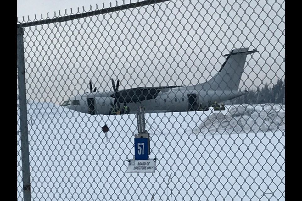 Firefighters check the cargo hold of an airplane after they were called out to the Prince George airport on Friday afternoon. Officials could not be immediately reached for details.