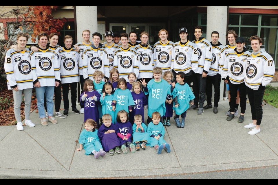 Victoria Grizzlies players with children from the daycare operated by the Military Family Resource Centre. The Grizzlies and the resource centre are teaming up for a fundraiser at The Q Centre on Friday.