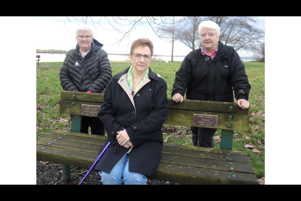 Lynne Barclay (centre), Bonnie Ross (left) and Margaret Galawan are appealing to the City of Richmond's better nature to allow them to have three plaques, remembering each of their late husbands, placed on a city bench overlooking the Finn Slough in south Richmond. Alan Campbell photos