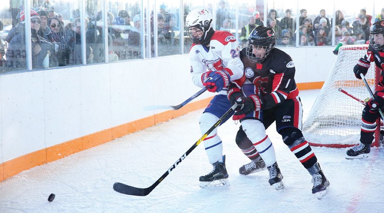 Booker Daniel of the Cariboo Cougars, right, battles for the puck against Jackson Murphy-Johnson of the Vancouver Northeast Chiefs during Sunday’s Winter Classic at Ernie Sam Memorial Arena, located on Nak’azdli Whut’en territory in Fort St. James. – Citizen photo by James Doyle