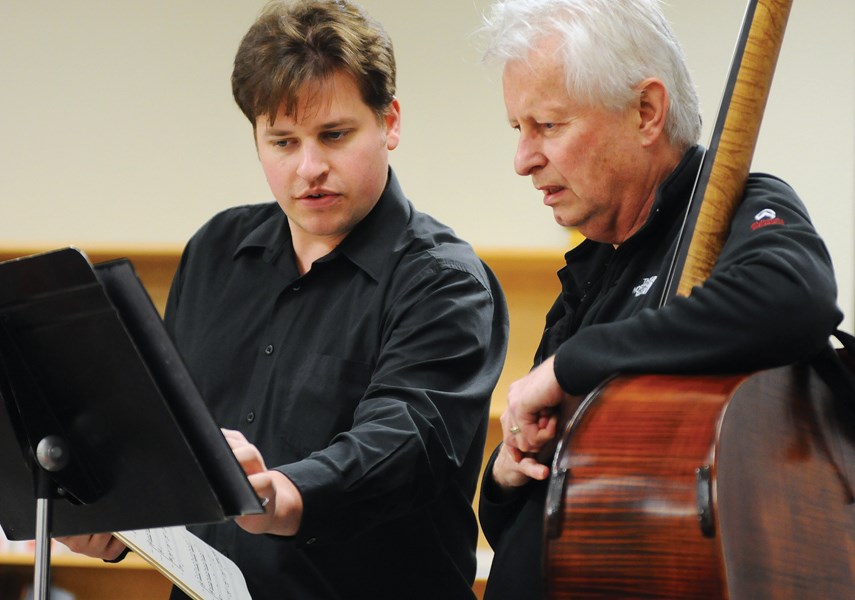 Composer Alex Clark and bassist Casey Tolhurst go over sheet music during a rehearsal with the North Shore Chamber Orchestra.