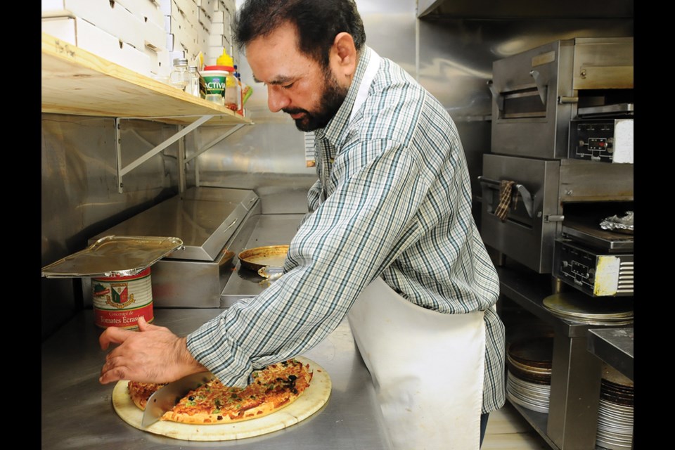Owner Kamaljeet Singh slices up a Mr. Pan Supreme Pizza. Mr. Pan’s pizza and Indian food menus are robust, each offering an array of stalwarts in their respective categories, from Hawaiian pizza to Lamb Vindaloo and Butter Chicken.