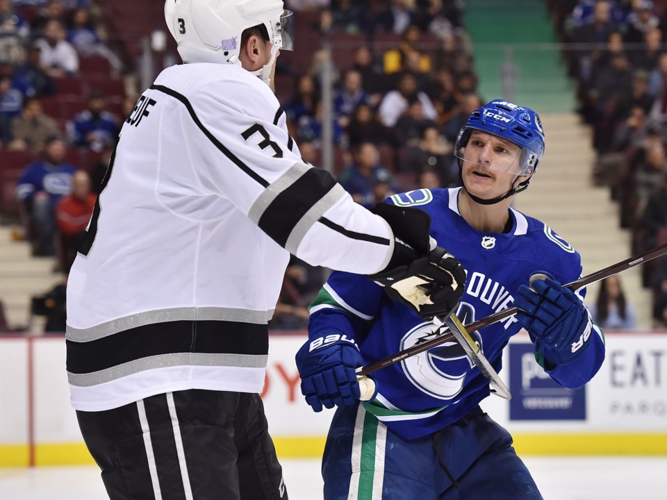 The Canucks' Antoine Roussel confronts the Kings' Dion Phaneuf.
