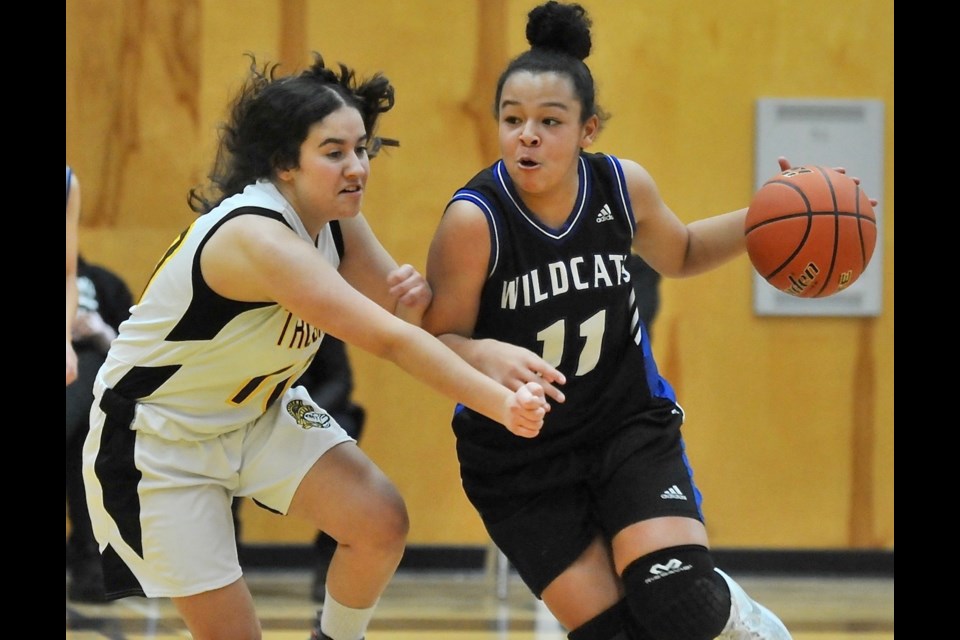 McMath's Kiayra Hohlweg is guarded by Boyd's Sara Bursac in Wednesday night's Richmond Juvenile Girls championship game. Hohlweg led the Wildcats to a 36-28 win over the host Trojans.