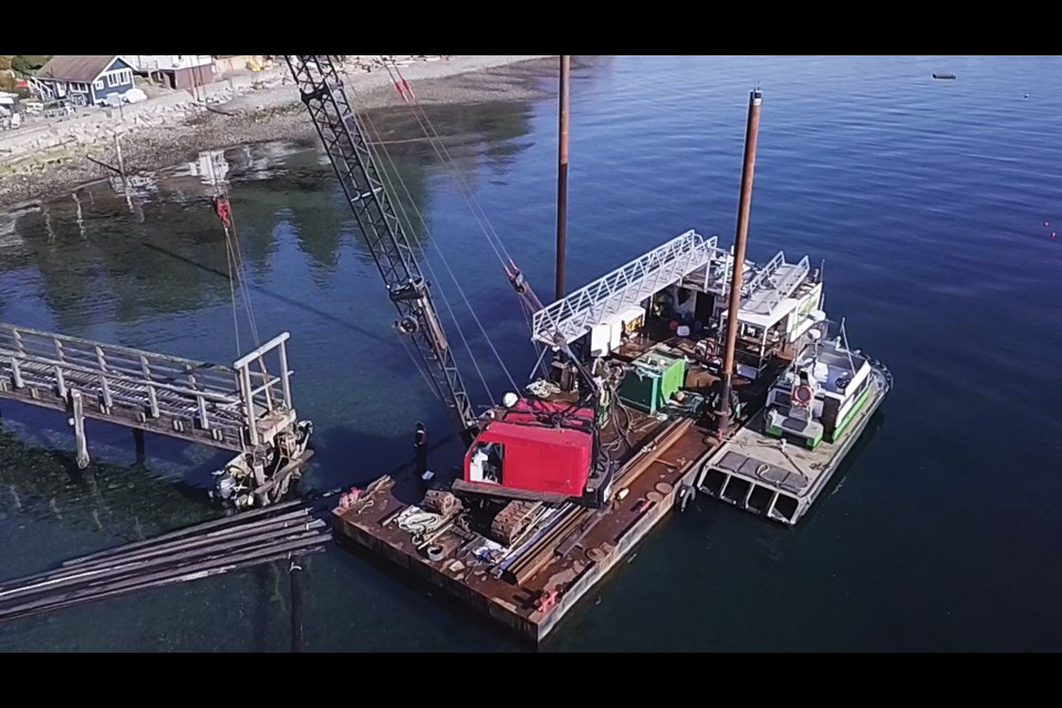 Green Wave Marine's pile-driving barge on site at the Granthams Landing Wharf last week, using their crane to lift the end of the wharf platform to install new pilings and beams to strengthen and support it.