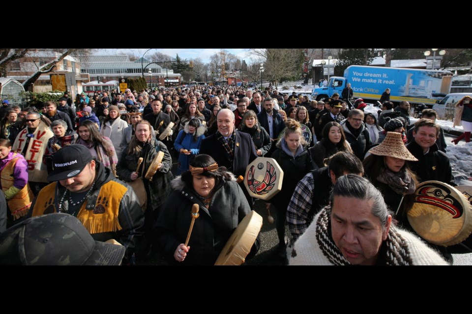Premier John Horgan, centre, with drum in hand, joins a walk from Thunderbird Park to the steps of the legislature to support the Moose Hide Campaign.