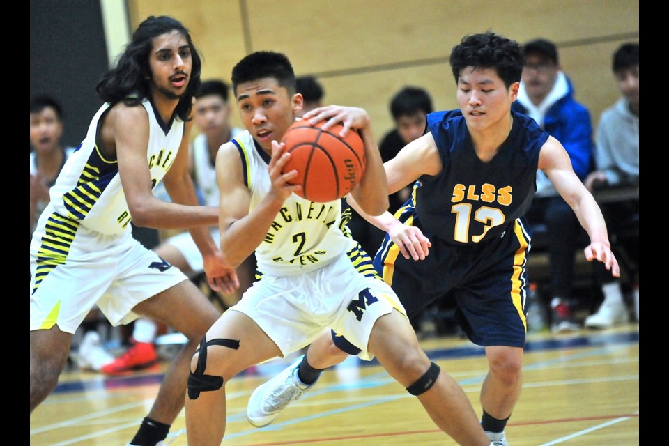 MacNeill's Nikko Bondoc is guarded by Steveston-London's Kouki Kawano with teammate Usman Tung looking on in Wednesday night's semi-final action at the Richmond Senior Boys Basketball Championships.