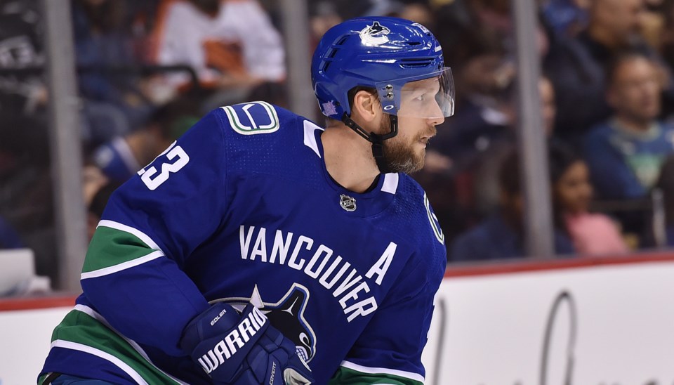 Alex Edler looks up ice with the puck for the Vancouver Canucks.