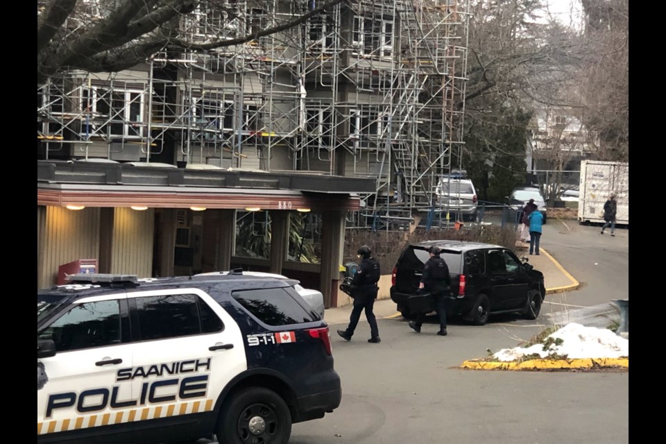 Tactical officers are seen bringing remote-controlled detection equipment into the building at the scene of a weapons call on Vernon Avenue and Saanich Road this morning.
