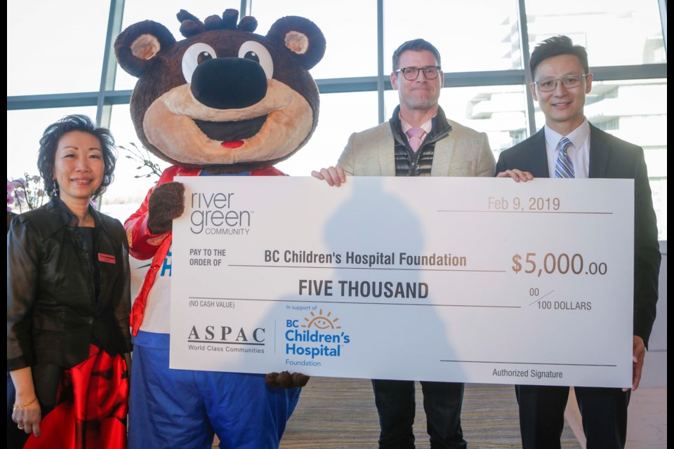 Ryan Laurin, Aspac Developments presents a donation of $5,000 to Sunny Leung, Director of Philanthropy to BC Children’s Hospital Foundation (BCCHF) for the “One Gift. Twice the Impact.” fundraising initiative with Mascot Sunny Bear looking on.