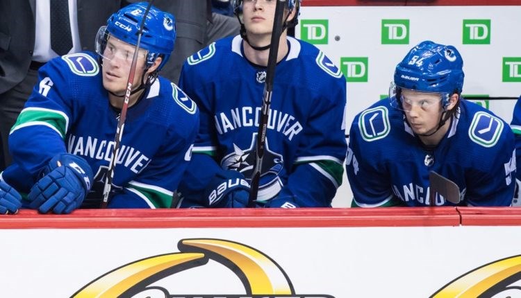 Jonathan Dahlen sitting alongside Brock Boeser and Elias Pettersson for the Vancouver Canucks.
