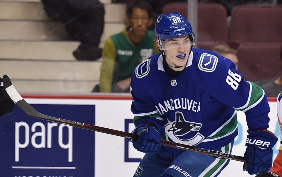 Adam Gaudette keeps an eye on the puck for the Vancouver Canucks.