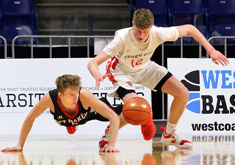 Terry Fox Ravens guard Cameron Slaymaker battles for a loose ball with a Mt. Baker Wild defender in the second half of their opening round game at the BC High School senior boys AAAA basketball championships, Wednesday at the Langley Events Centre. Fox won the game 119-45.