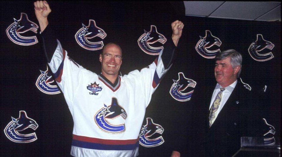 Mark Messier signs with the Vancouver Canucks.