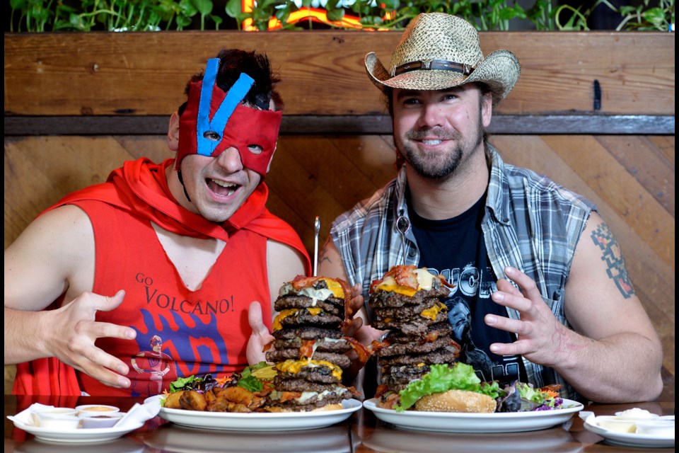 All smiles to start with: The Volcano, left, and Big Daddy Buck Lighting, who are among the wrestlers competing in the 20-person Royal City Rumble on March 30 in New Westminster, dropped by Burger Heaven on Saturday as part of a challenge to see who could eat a rumble version (10 patties) of Burger Heaven’s Ernie’s Mile High, eight-patty burger.
