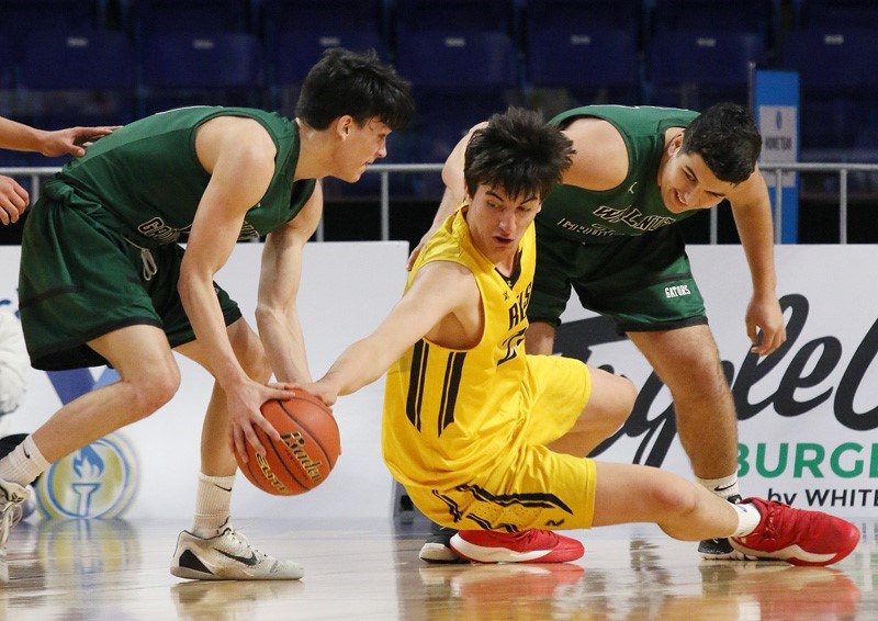 Burnaby South's Sasha Vujisic gets horizontal in a battle for the ball during the opening game at the B.C. 4-A senior boys basketball championships at the Langley Events Centre.