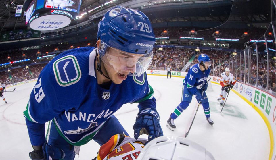 Ashton Sautner checks a player for the Vancouver Canucks.