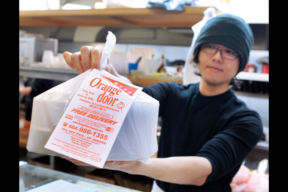 Orange Door manager Jackie Wong packs a dinner order at the Lower Lonsdale Chinese take-out restaurant.