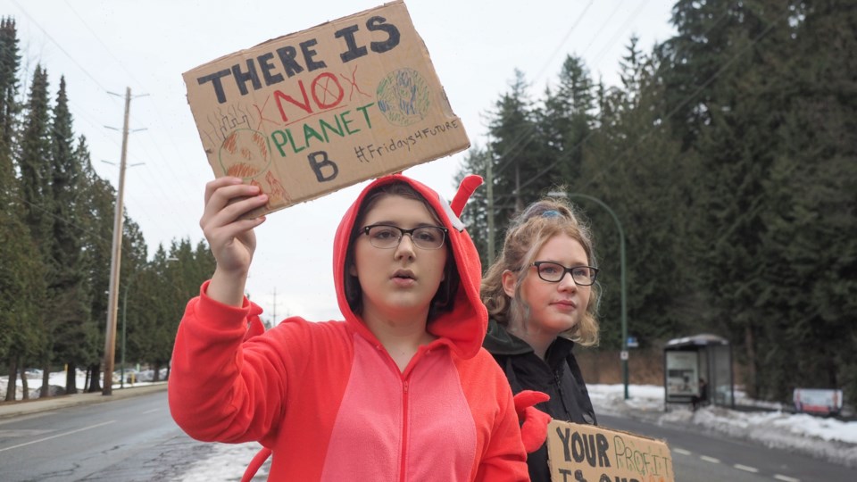 Students Megan Sweder and Rhema Plunkett protest along Como Lake Avenue