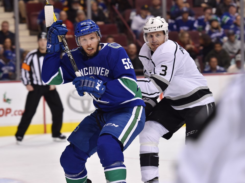 The Vancouver Canucks' Alex Biega battles with Dion Phaneuf of the Los Angeles Kings