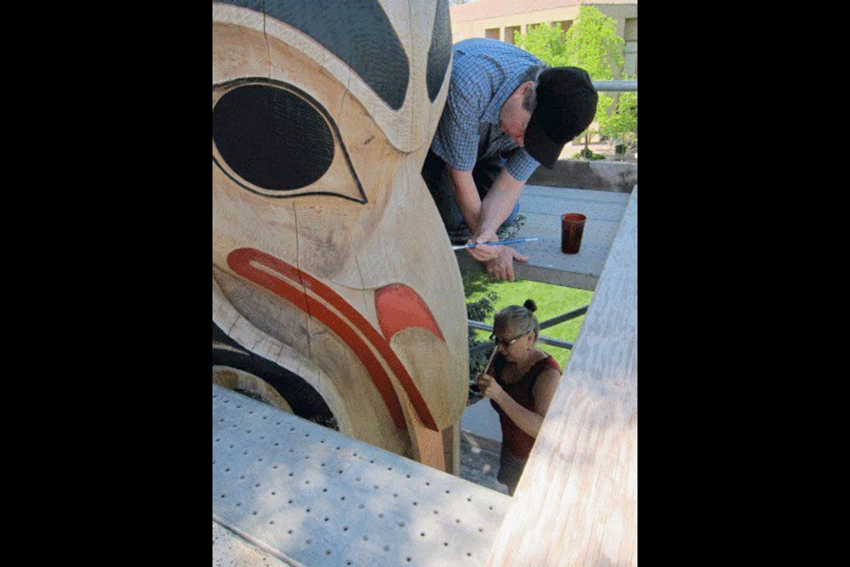 John Livingston is shown restoring totems at Stanford University in Palo Alto, California, with his wife, Maxine Matilpi.