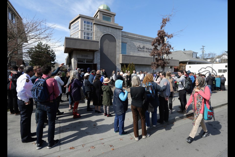 Hundreds take part in a protective human chain around the Masjid Al-Iman today.