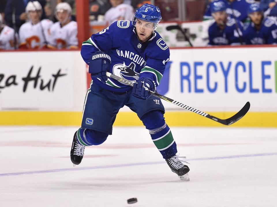 Derrick Pouliot plays the puck up ice for the Vancouver Canucks.