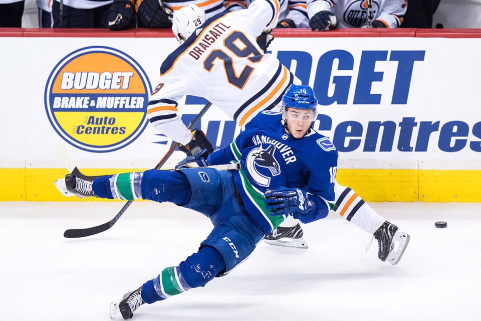 The Vancouver Canucks' Jake Virtanen misses a hit on Leon Draisaitl of the Edmonton Oilers.