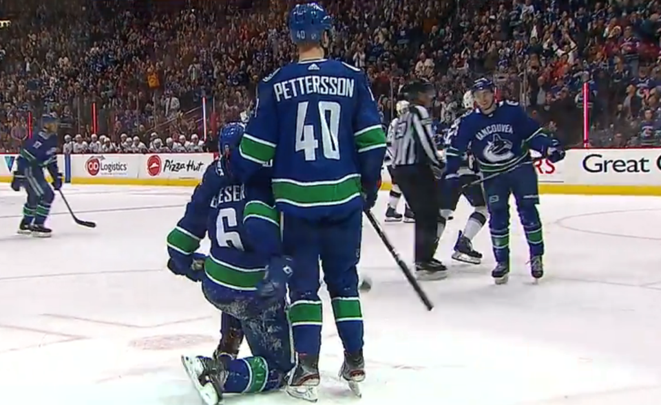 Brock Boeser & Elias Pettersson wait for Quinn Hughes to celebrate a goal for the Vancouver Canucks.