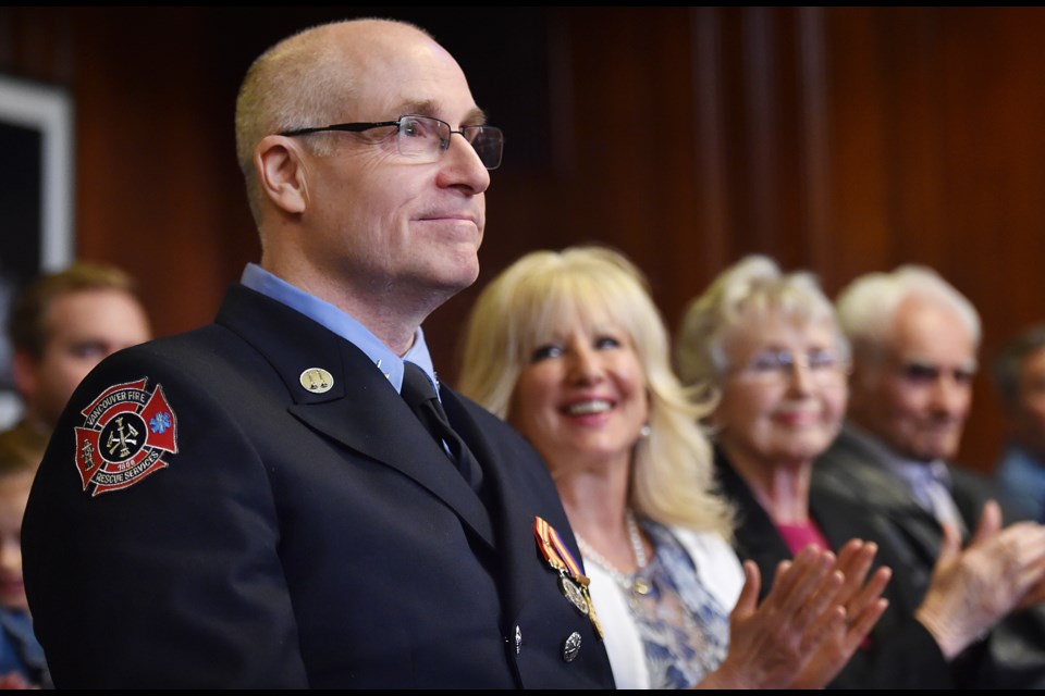 Capt. Steve Letourneau of Vancouver Fire and Rescue Services, seated next to his wife Dawn and parents, received a 35-year service medal at city hall Tuesday. Photo Dan Toulgoet