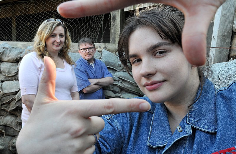 Kim Cleroux, the director of a student film project that was produced at the McKnight Centennial trench behind Port Moody's Station Museum, frames a scene as teacher Corine Carey and museum coordinator Markus Fahrner look on.