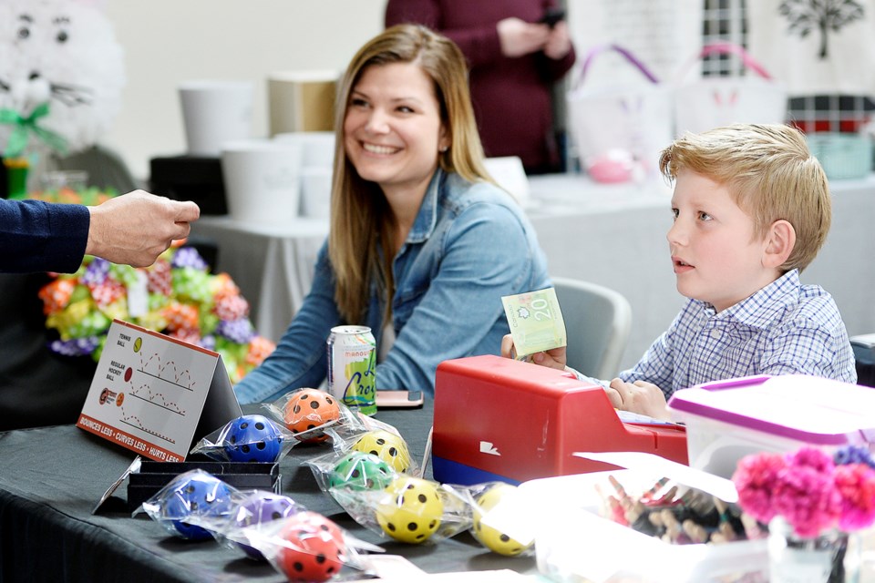 Eight-year-old Gage Whitfield, with his mom, Angie, sells G Street Hockey Balls at the fourth annual F.W. Howay Elementary School craft fair held on Saturday, March 30 at River Market. The fair is an annual fundraiser for the school’s parent advisory council.
