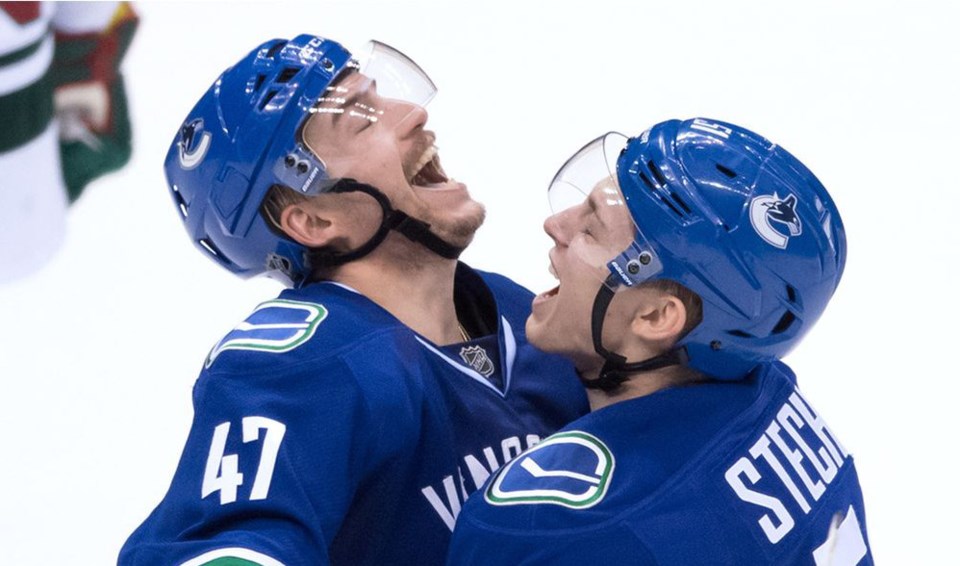 Sven Baertschi celebrates a Vancouver Canucks goal with Troy Stecher.