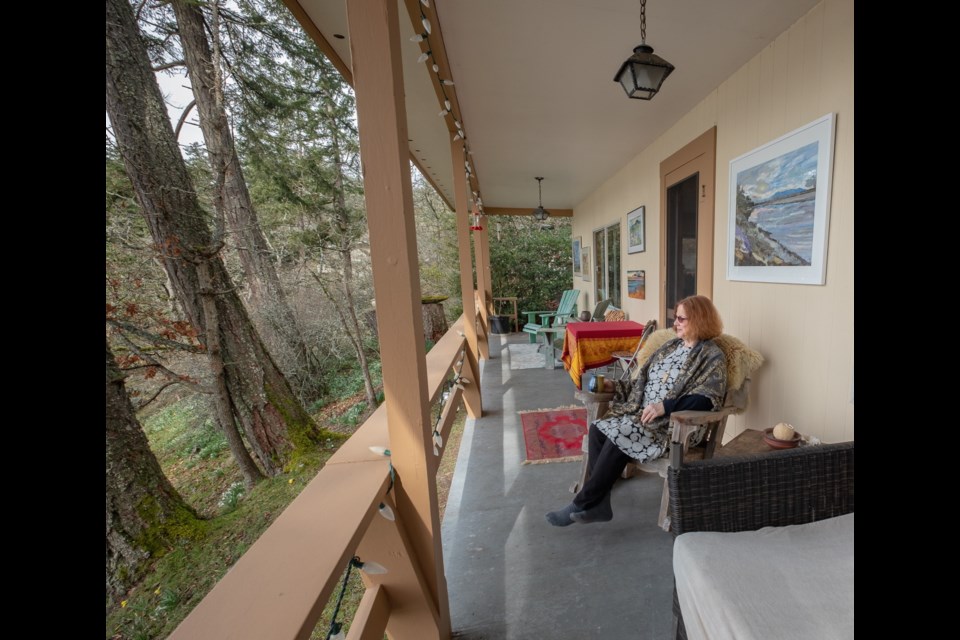 Catherine Fraser enjoys the deck of her cottage overlooking the Cowichan estuary. Her work will be on display at her studio next weekend in the Cowichan artisans studio tour.