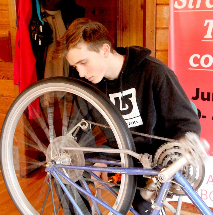 Thomas Bement examining a bicycle at a 2017 Fix-it Fair.