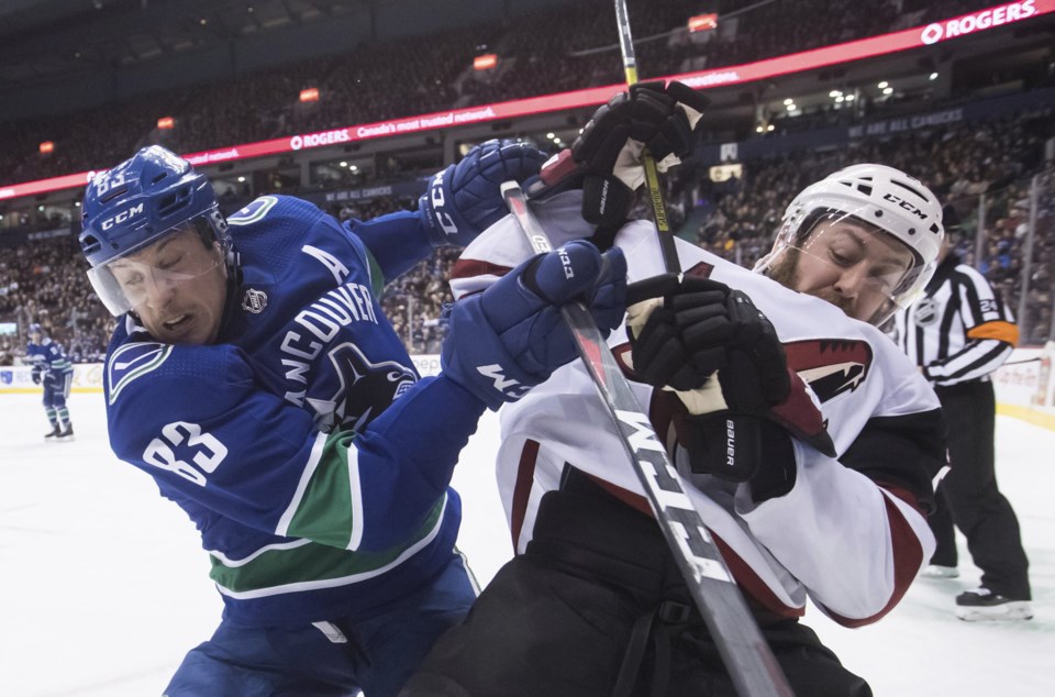 Jay Beagle of the Vancouver Canucks battles Derek Stepan of the Arizona Coyotes for the puck.