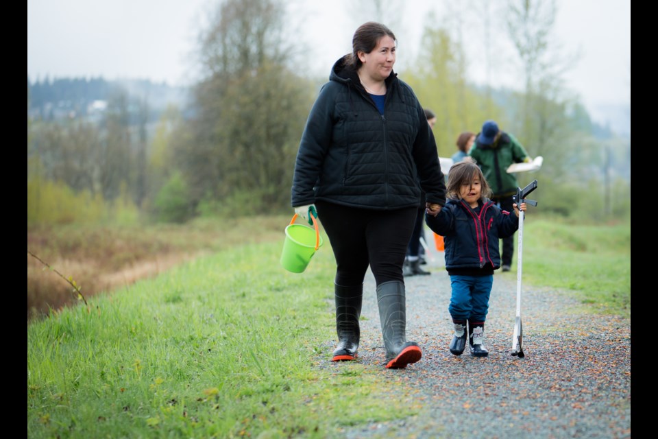 Kwikwetlem cultural leader Nancy Chaffee and her son Jamie walk along a dike of the Coquitlam River on their way to collect trash.