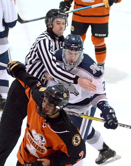 Burnaby's Jonathan Sheardown, in white, is restrained by a linesman during the Pacific Junior B Hockey League playoffs. The 20-year-old North Van Wolf Pack defender scored the game-winning goal in the team's final game of the season, securing a bronze medal at the Cyclone Taylor Cup tournament.