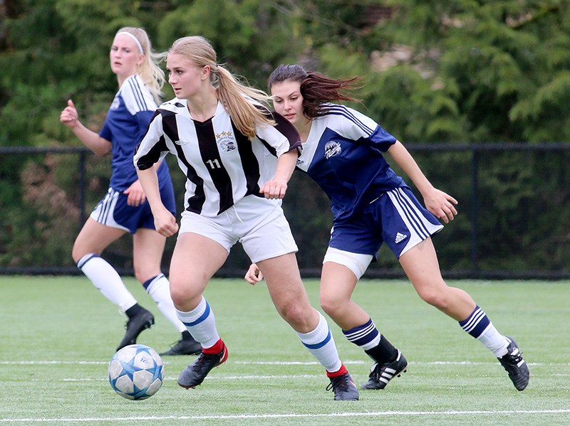 MARIO BARTEL/THE TRI-CITY NEWS Dr. Charles Best Blue Devils midfielder Valerie Silva tries to elude the marking of Riverside Rapids defenders Amy Vegh andSophie Irvine in the first half of their Fraser Valley North senior girls high school soccer match, last Wednesday at Dr. Charles Best secondary. The Blue Devils won the match, 3-1.